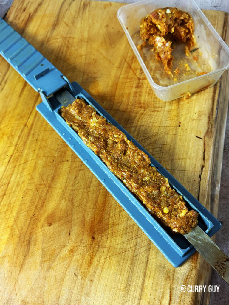 Filling a kebab mould with the meat.