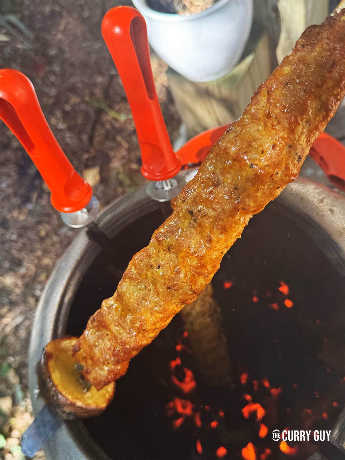 Taking a kebab out of the tandoor.