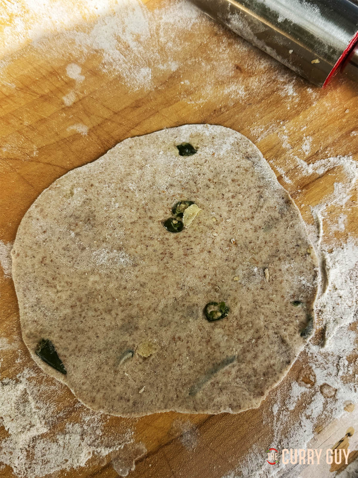 Rolling out a dough ball to form into a roti.
