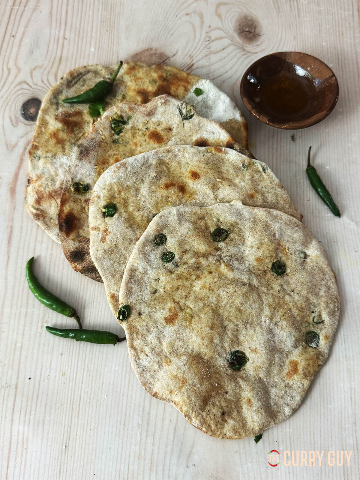 Tandoori roti with chillies and garlic on a countertop.