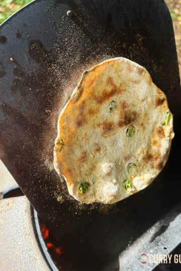 Tandoori roti with chilli and garlic on a naan pan cooking in the Doori tandoor oven.
