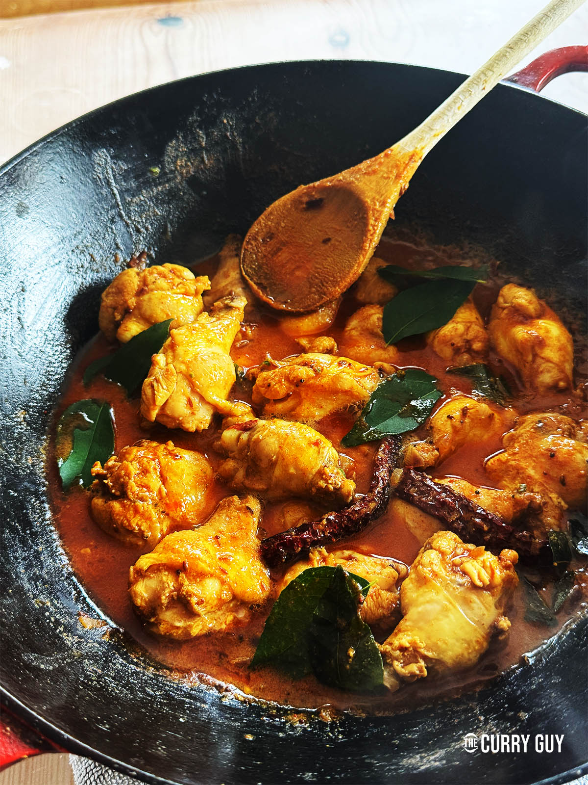 Curry chicken wings in a wok.