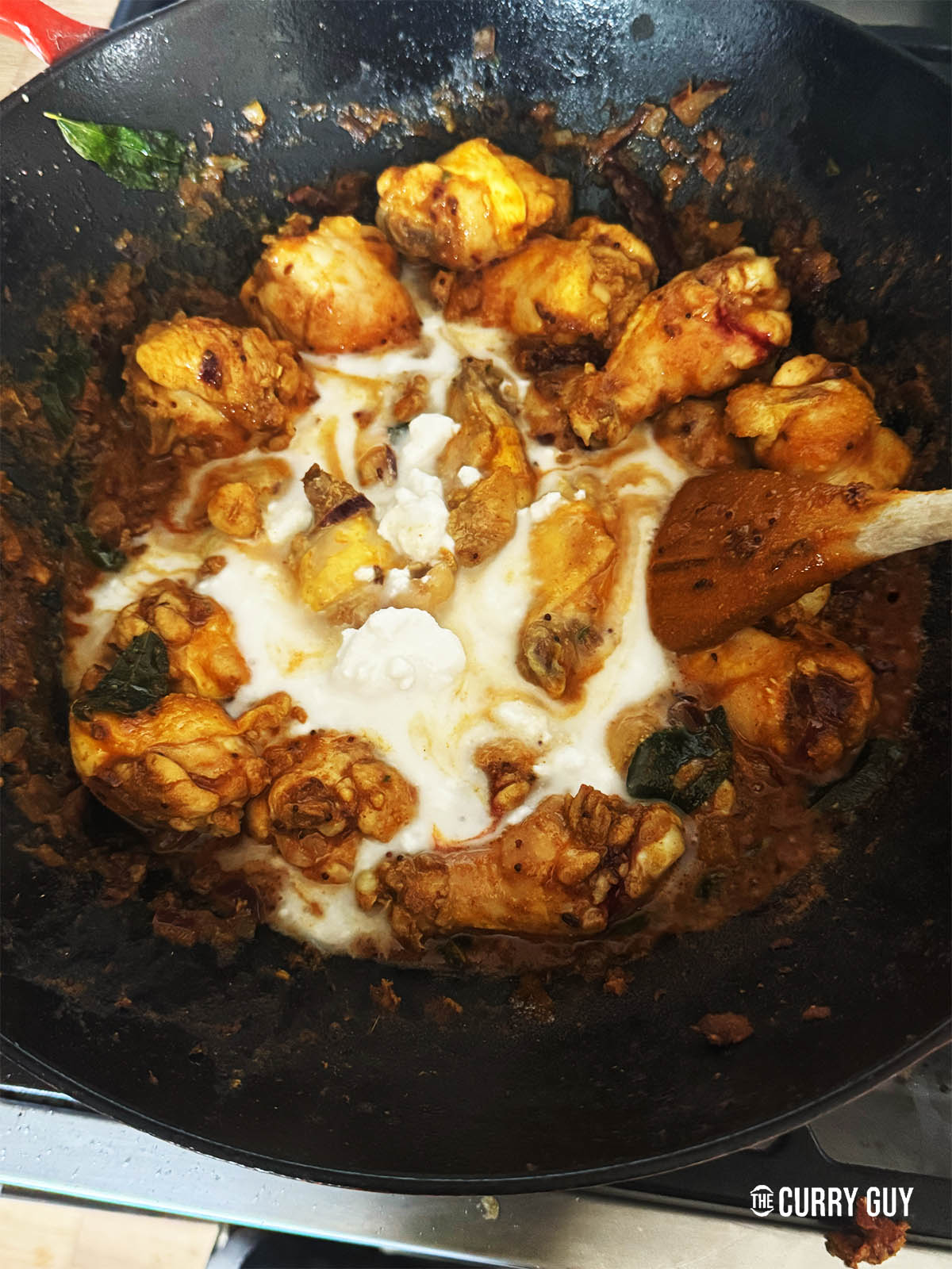 Adding coconut milk to the sauce.