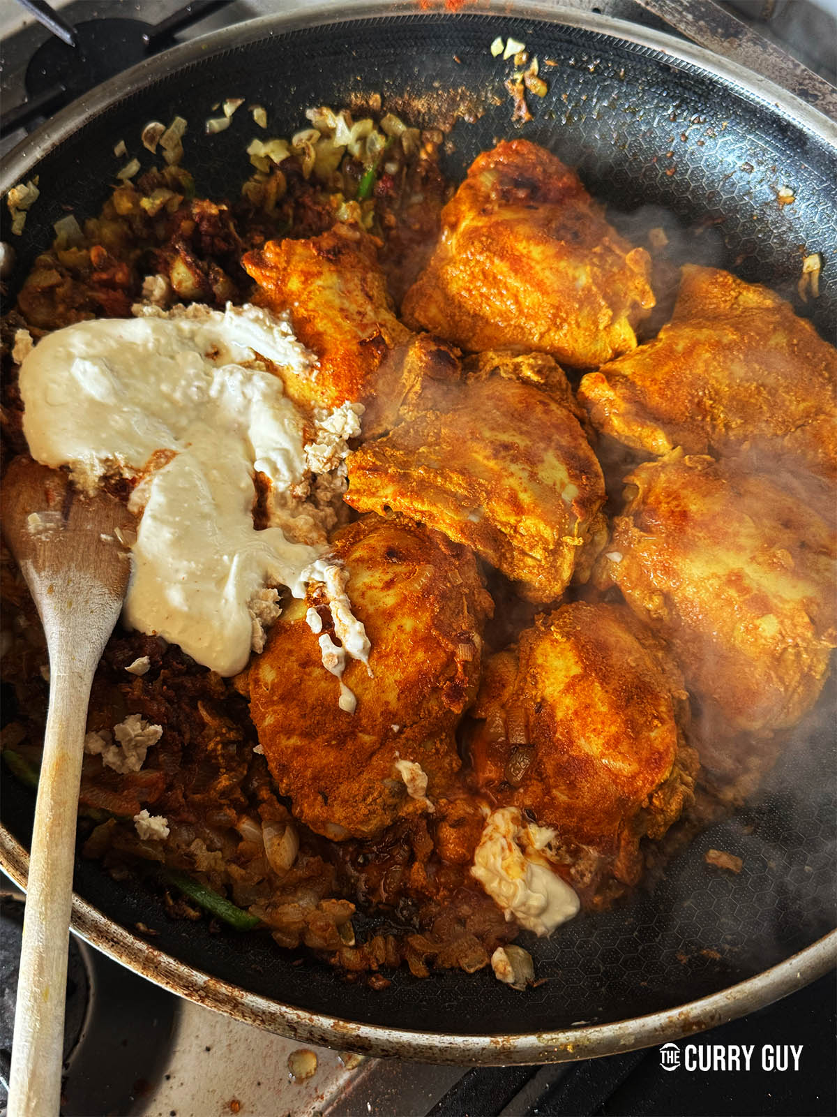 Adding the cashew paste and yoghurt to the pan.