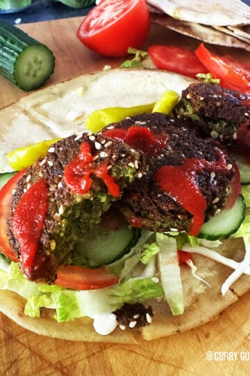 felafel on a flat bread with salad vegetables and sauces.