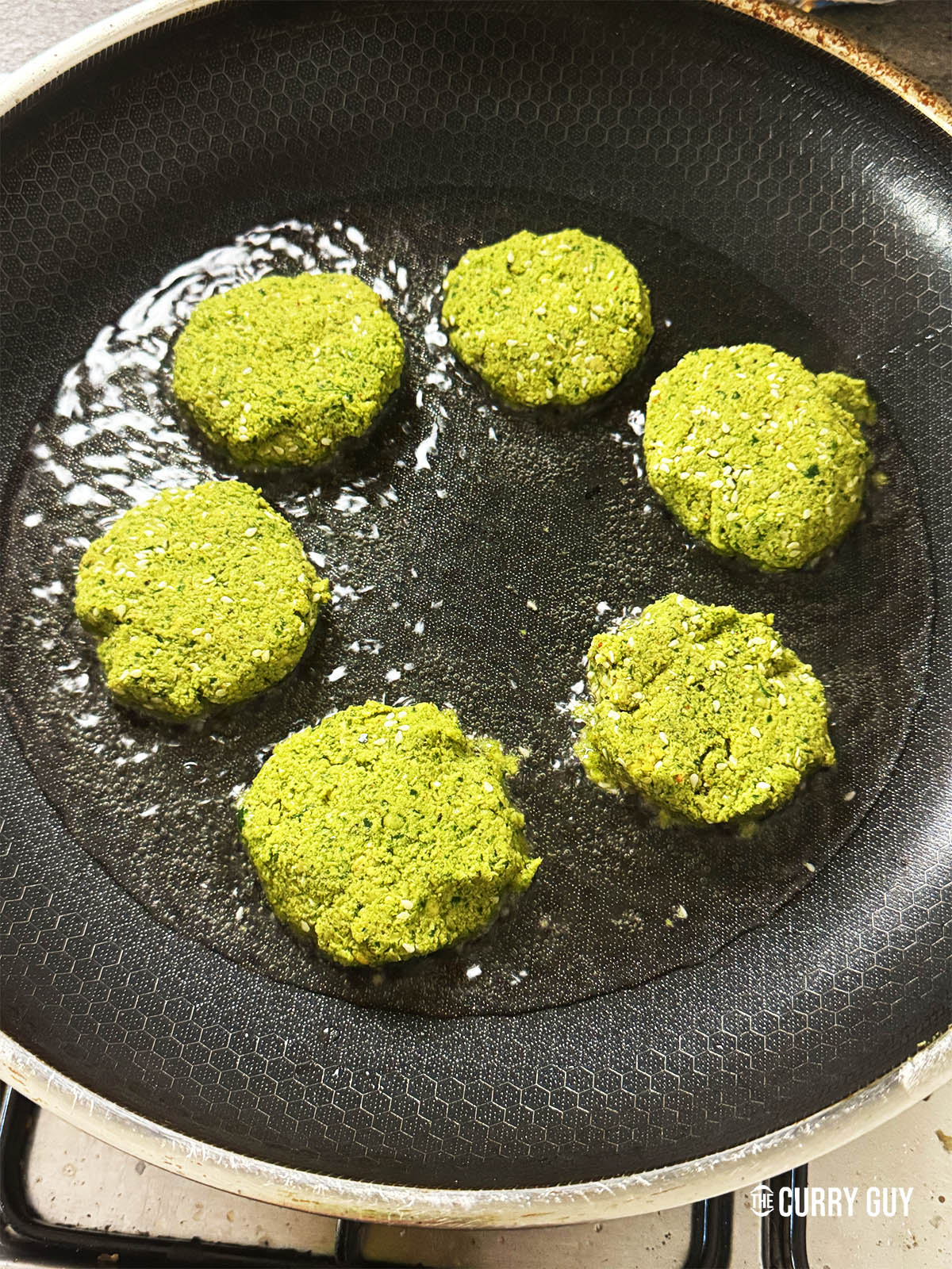 Frying the felafel in oil in a frying pan.