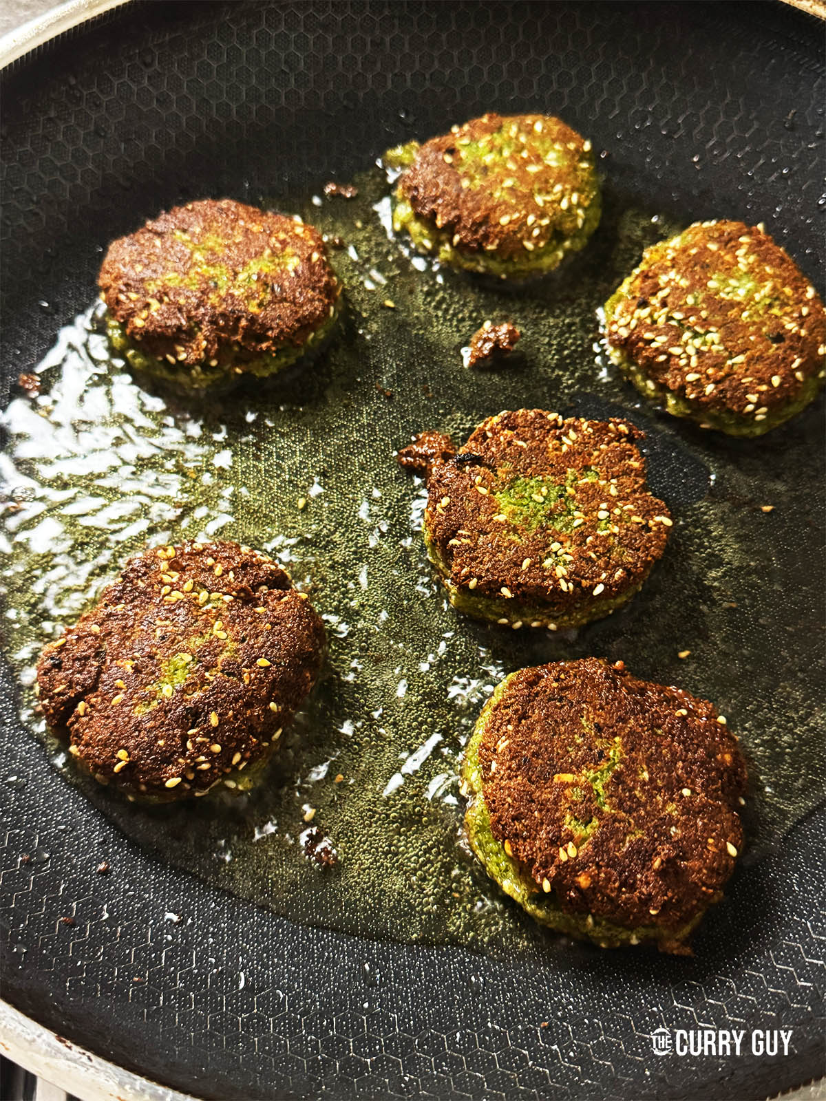 Felafel frying in a pan.