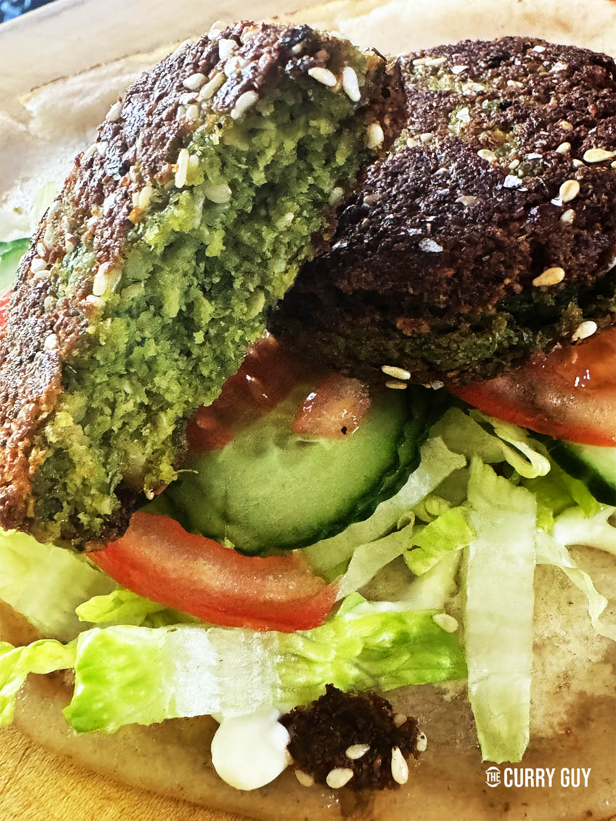 Tearing a felafel open to show the green center.