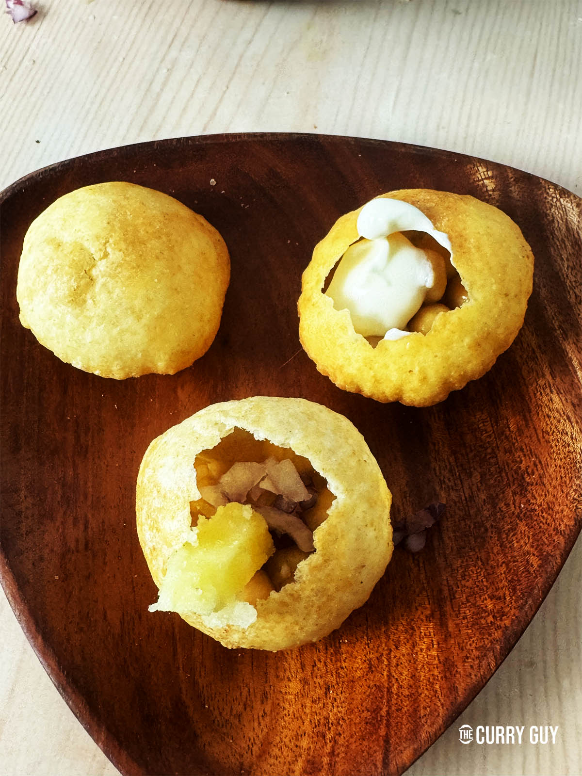 Filling the puris with a selection of fillings like potato, chickpeas and yoghurt.