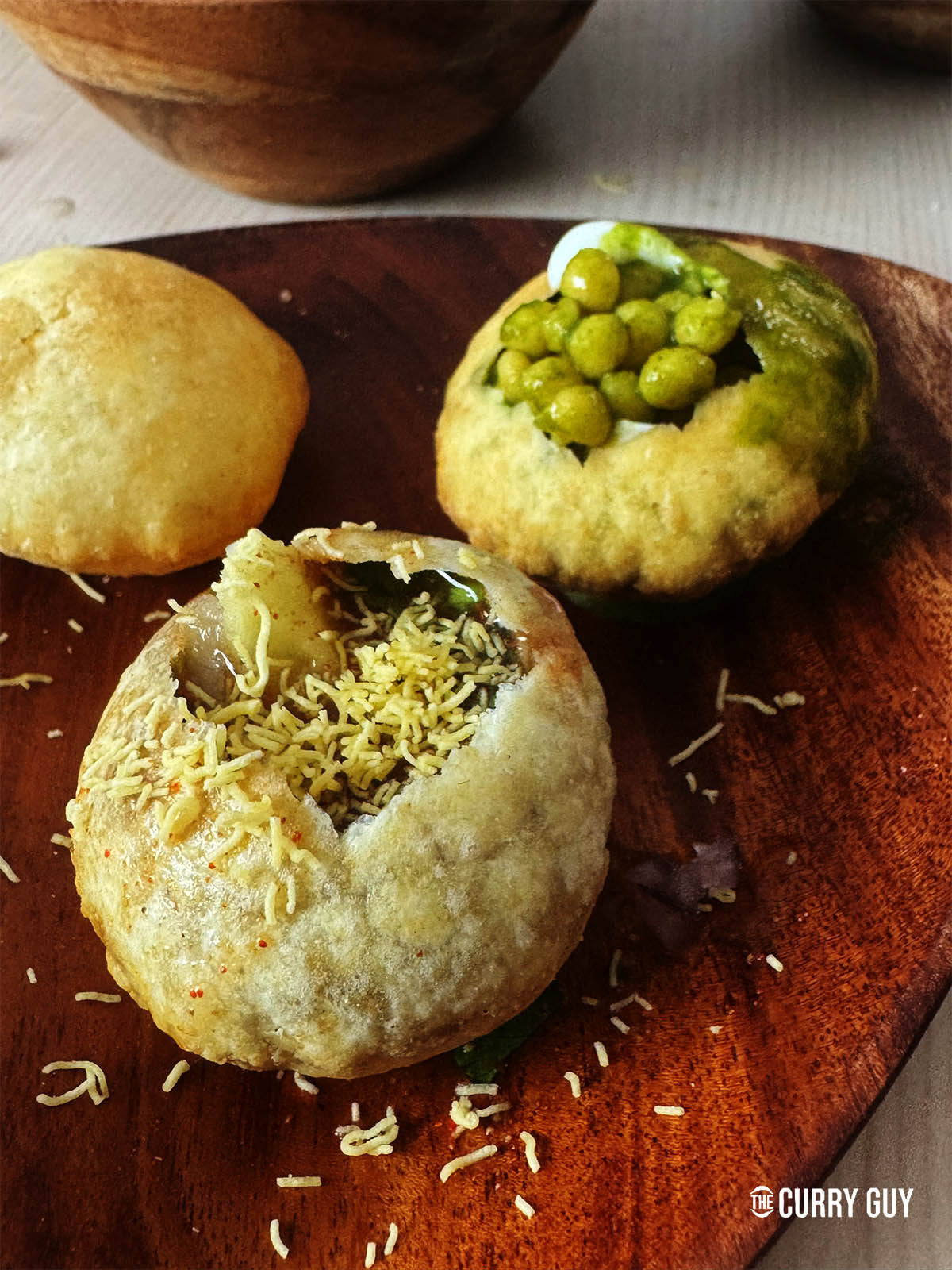 The pani puri fillies with onions, sev, bundi, black and white pani, potatoes, chickpeas and yorghurt.