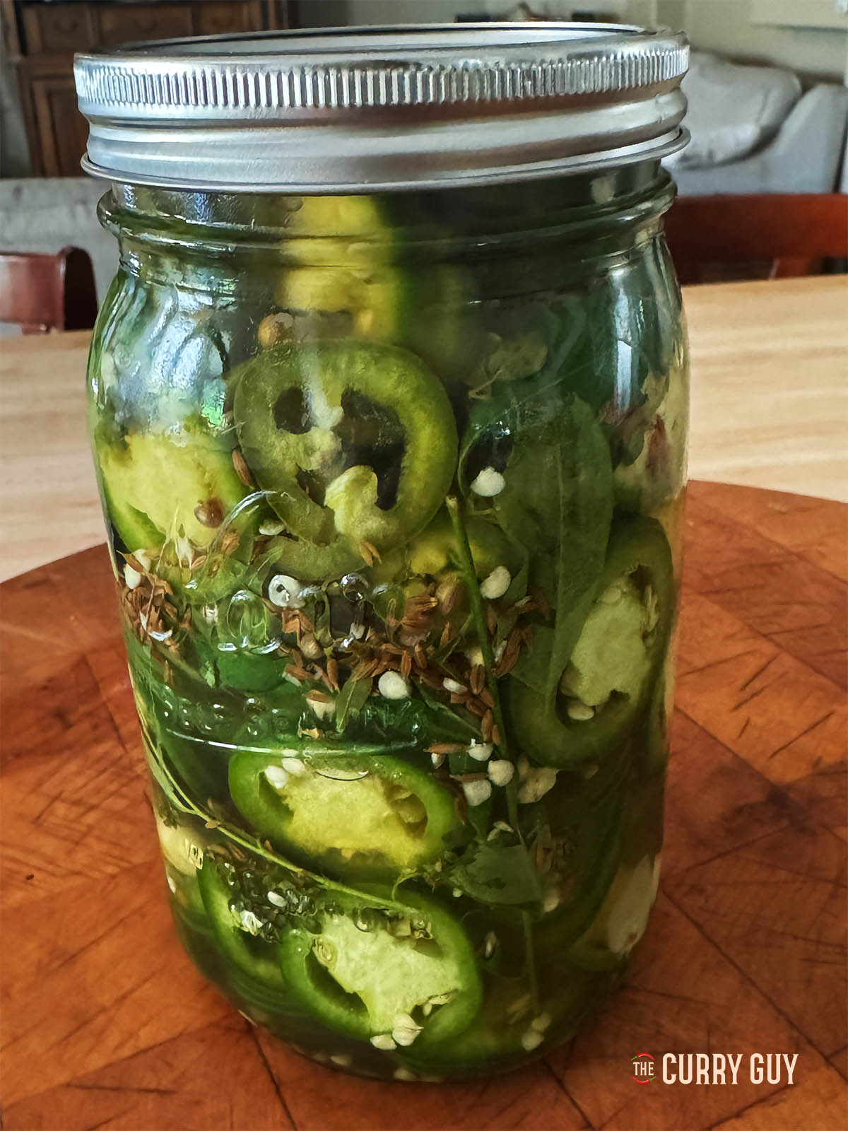 Pickled jalapeños in a preserve jar.