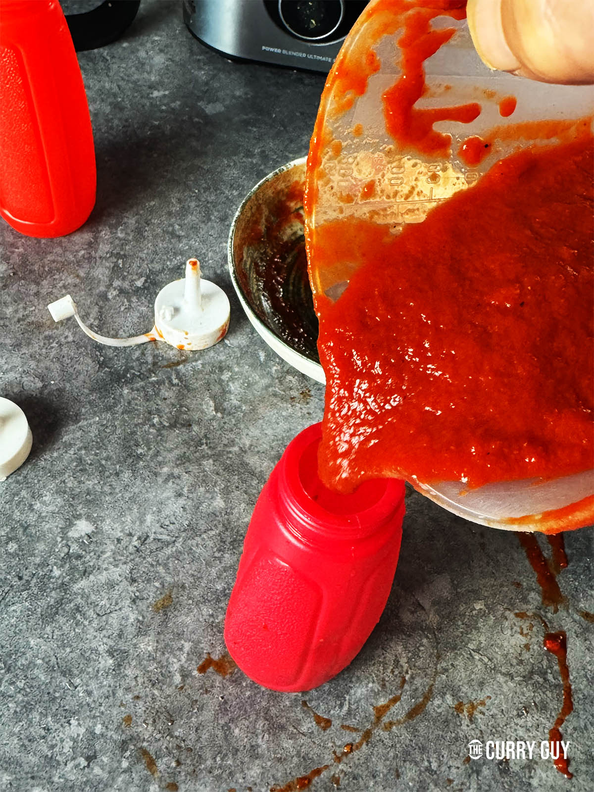 Pouring the sauce into a squeeze bottle.