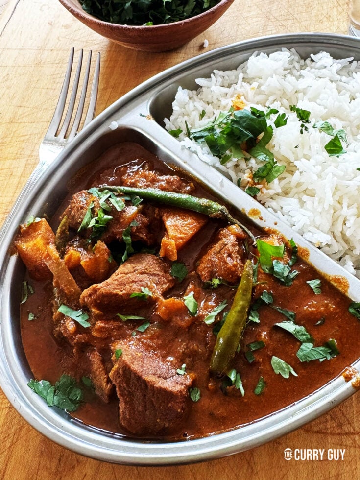 Shatkora curry with beef in a serving bowl with rice.