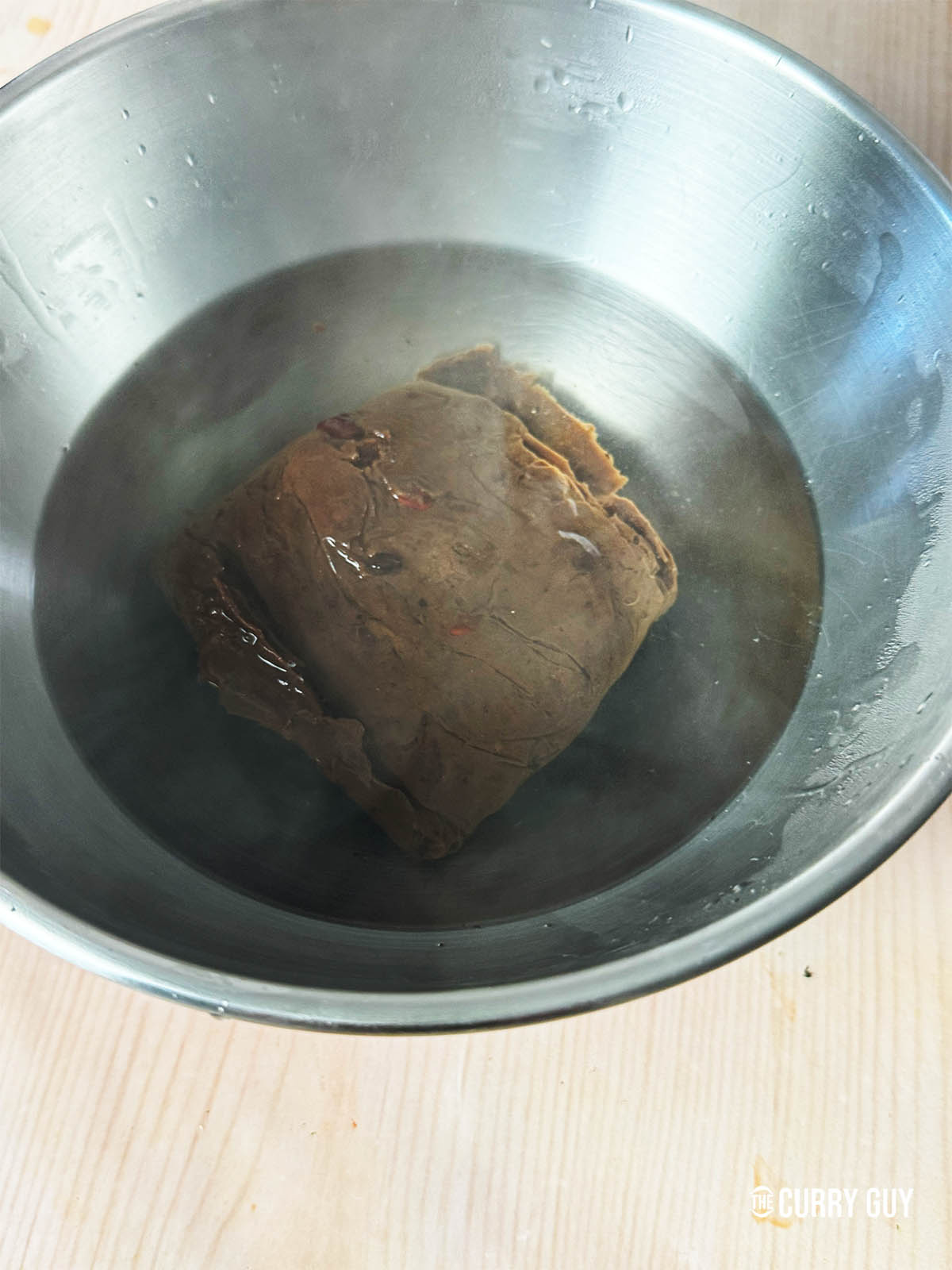 Soaking the block tamarind in hot water.