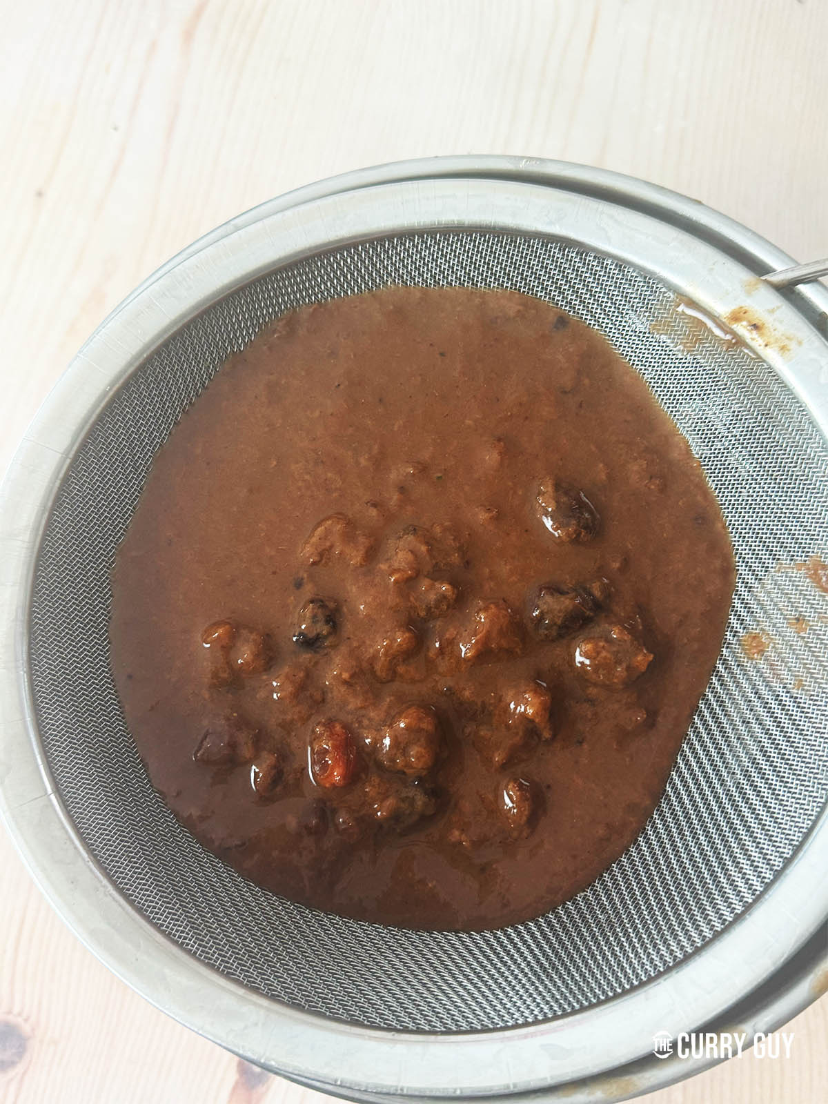 The tamarind mixture in a sieve.