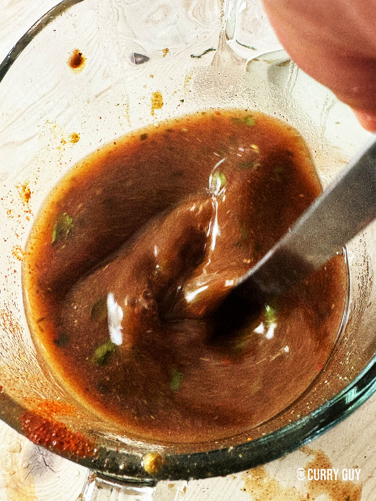 Stirring the tamarind water to combine all the ingredients.