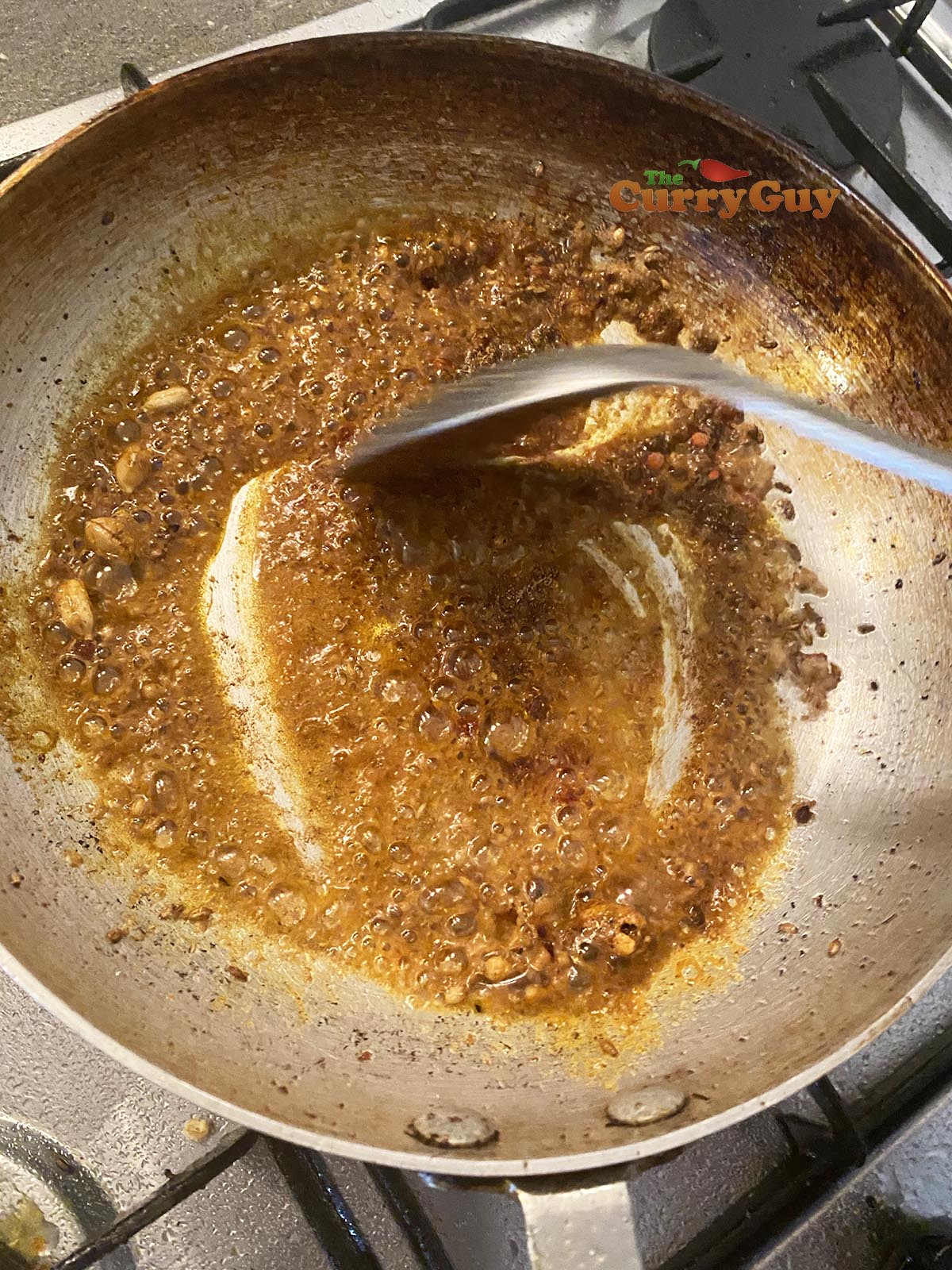adding base curry sauce to the pan