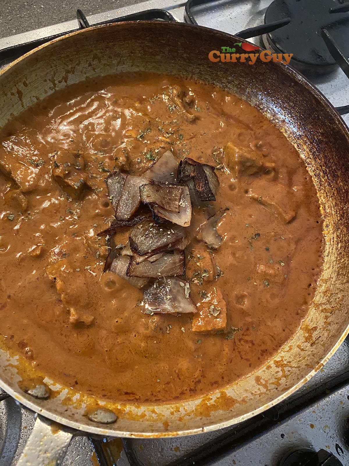 returning the fried onion petals to the lamb dopiaza