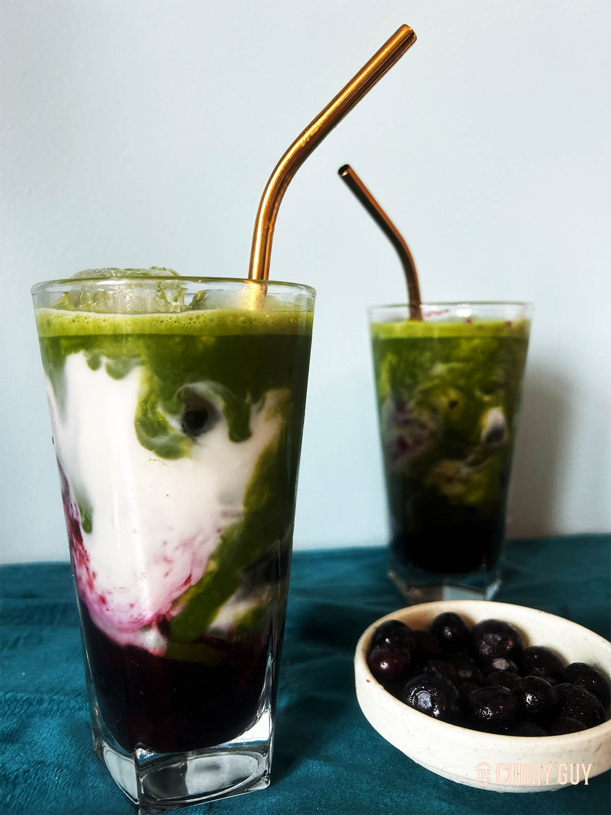 A tall glass of blueberry matcha.
