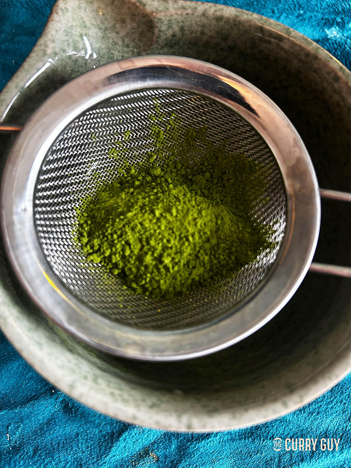 Passing the matcha through a fine sieve.