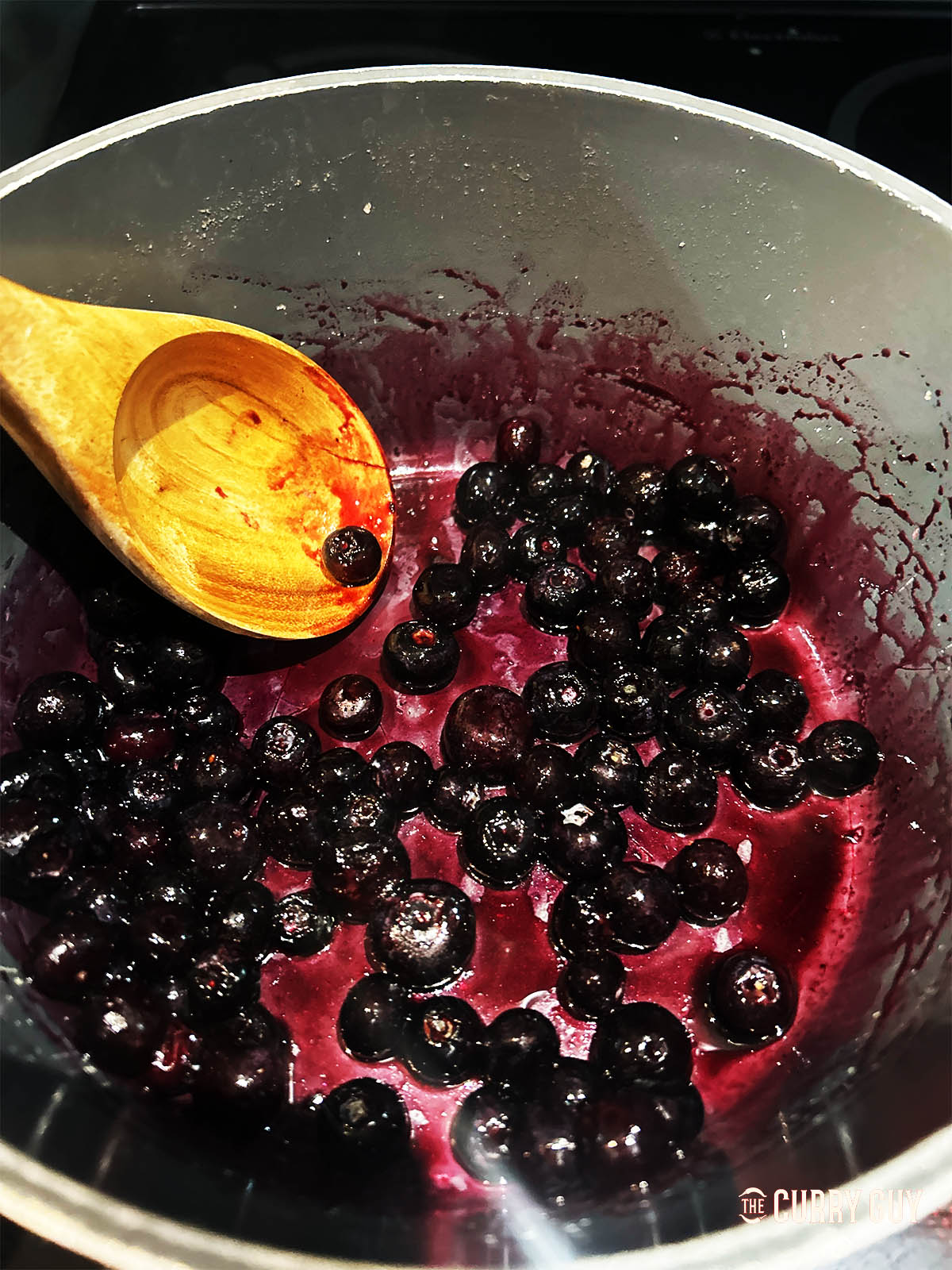 Adding the blueberries, honey and water to  a pot.