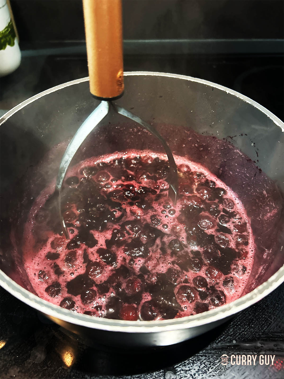 Mashing the blueberries as they simmer. 