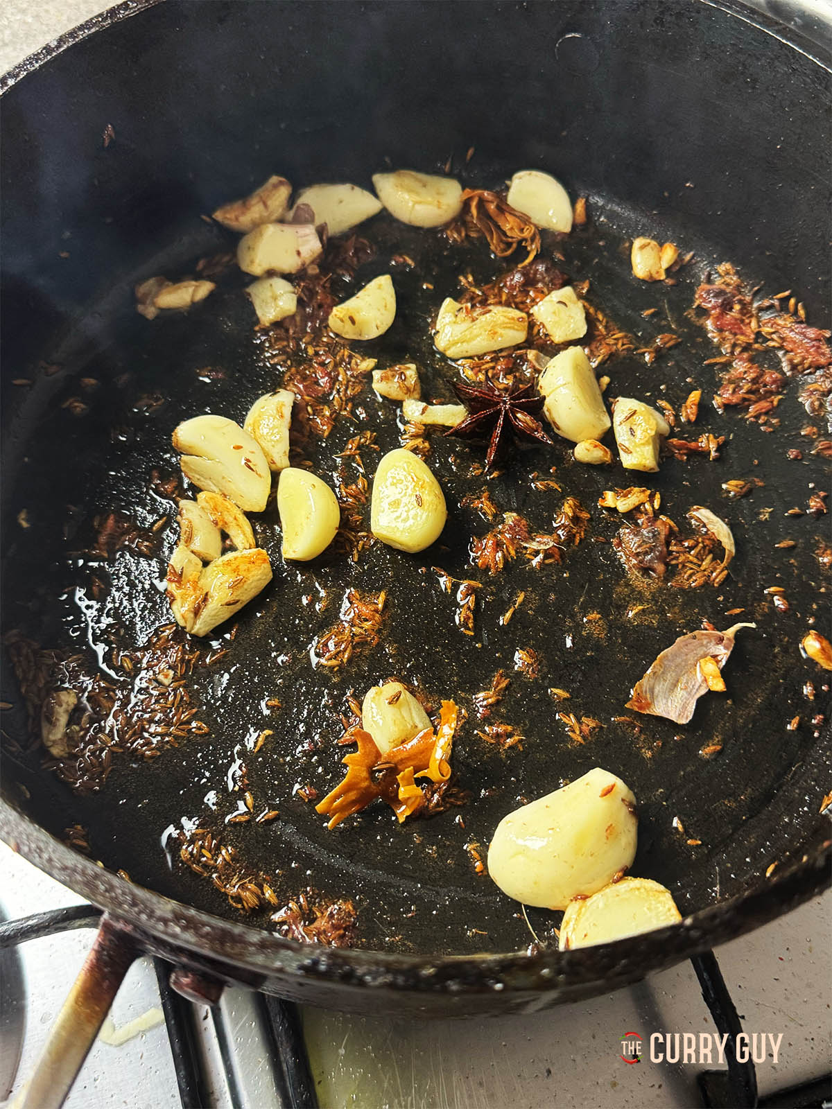 Adding the anchovies and garlic to the pan to roast the garlic and break the anchovies down. 
