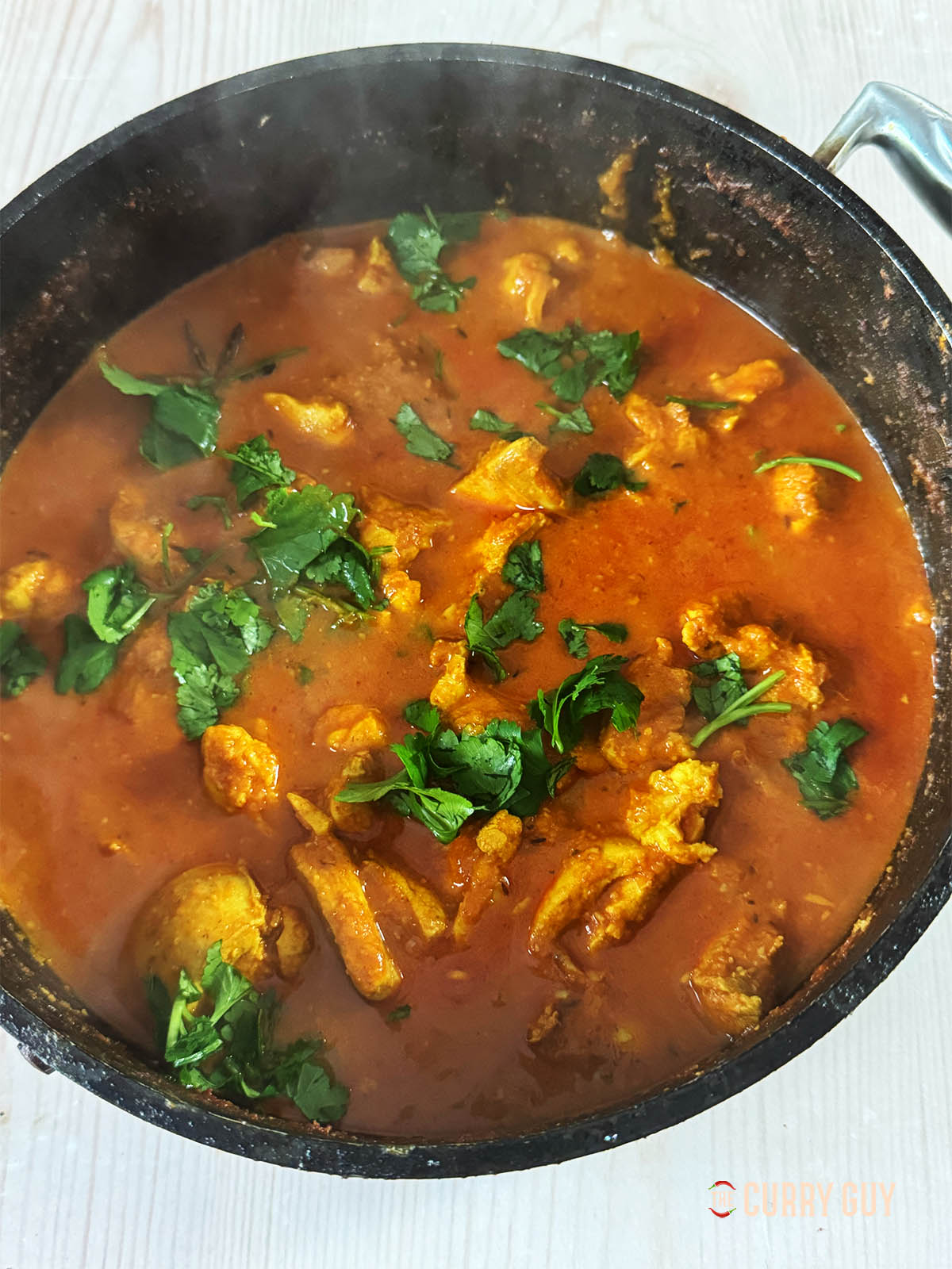 The finished garlic chicken curry garnished with coriander (cilantro).