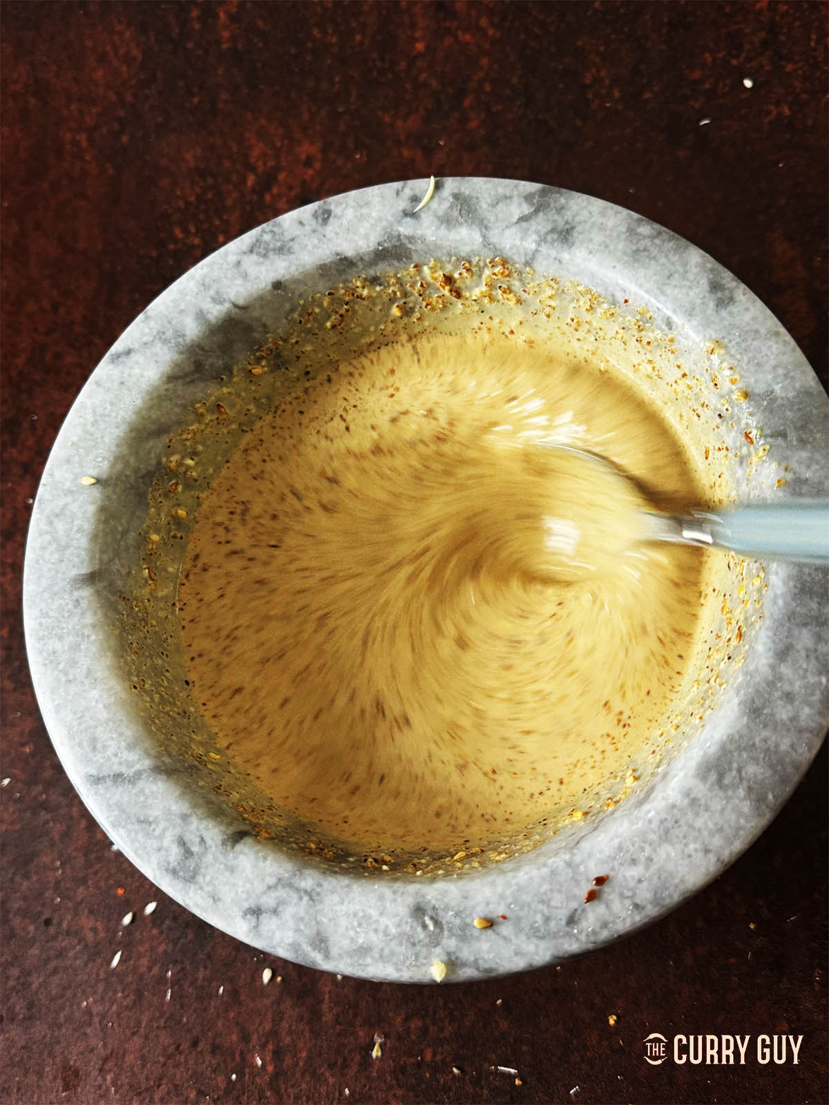 Whisking the salad dressing until smooth.