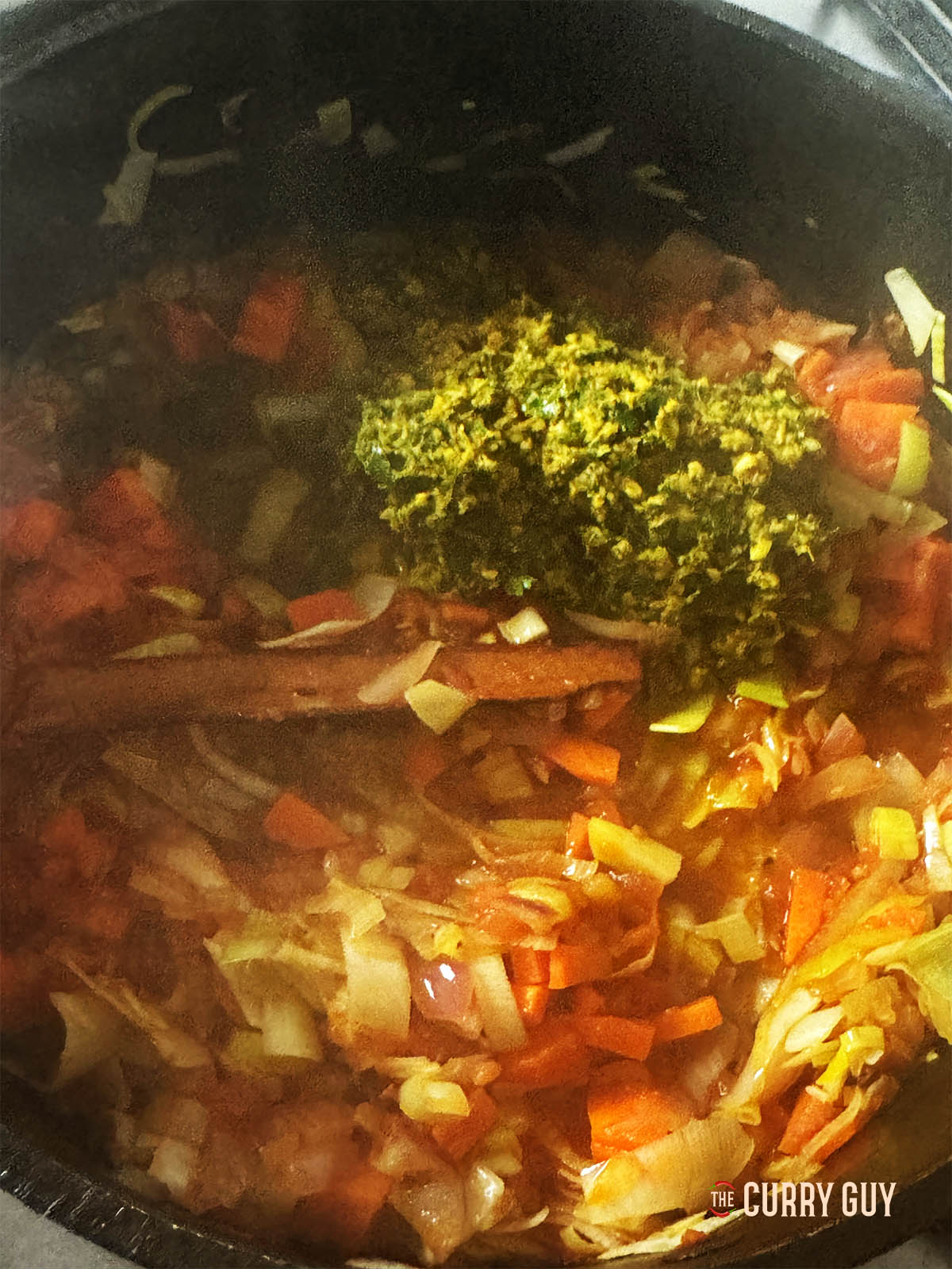 Adding the prepared spice paste to the soup.