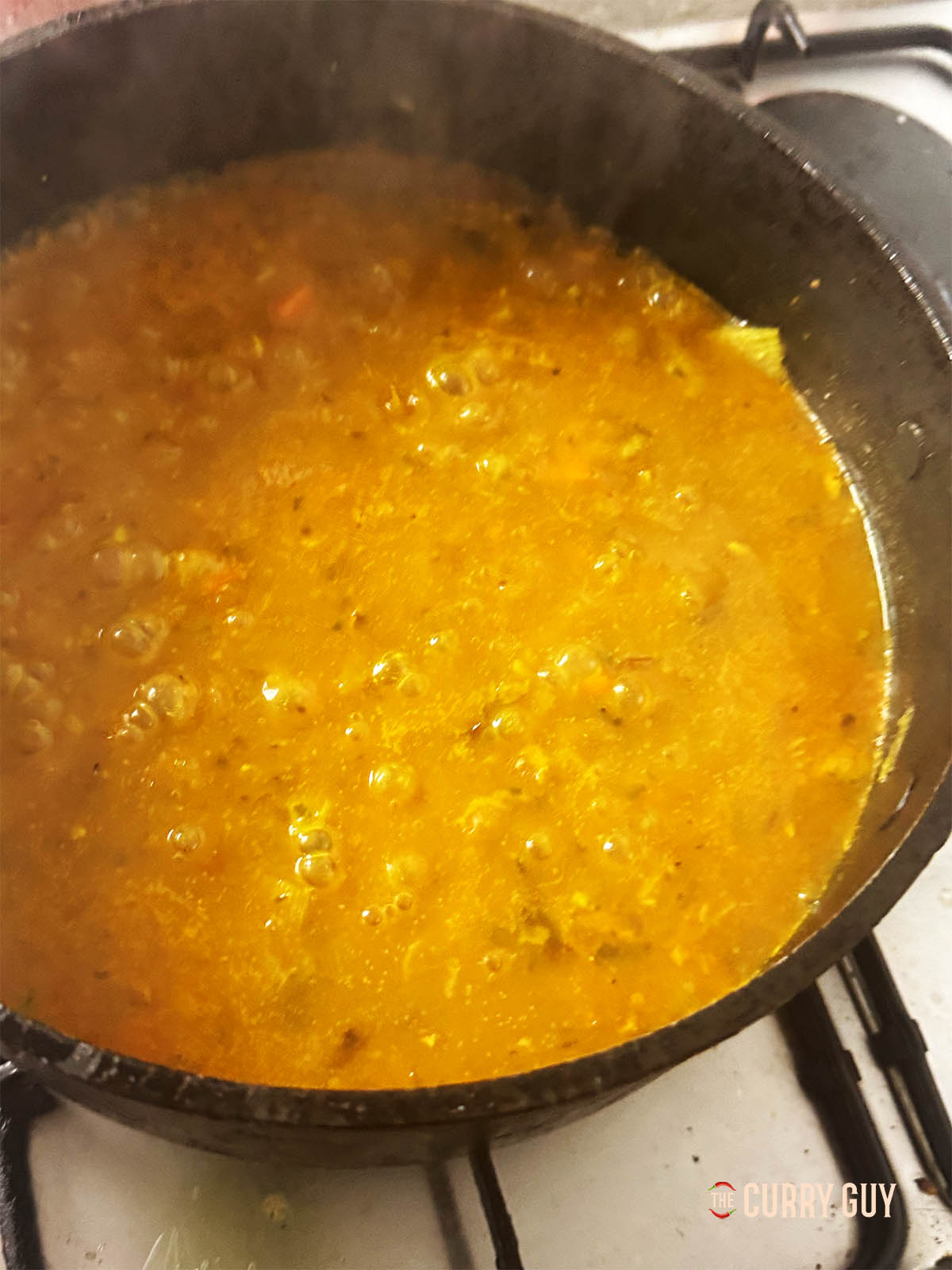 Adding the chicken stock to the pot.