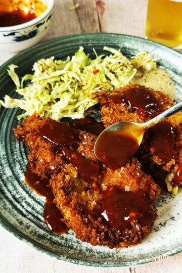 Tonkatsu on a plate with Japanese coleslaw.