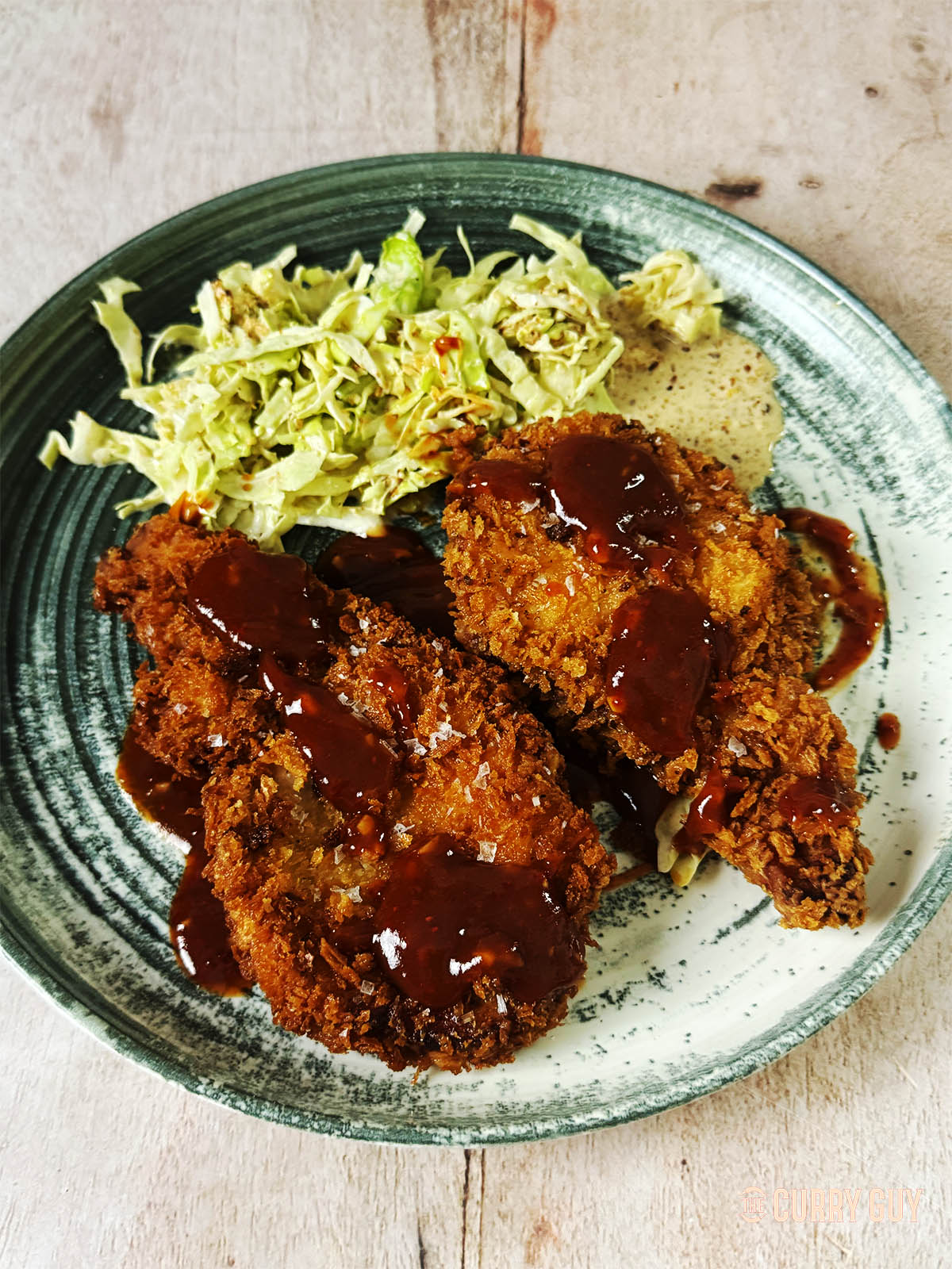 Tonkatsu on a serving plate with cabbage slaw.