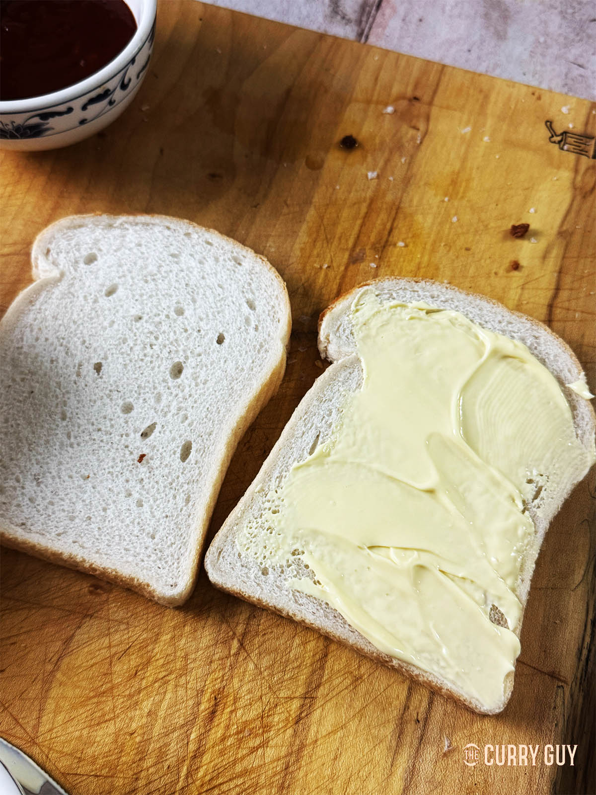 Spreading Japanese mayonnaise over the bread slices.