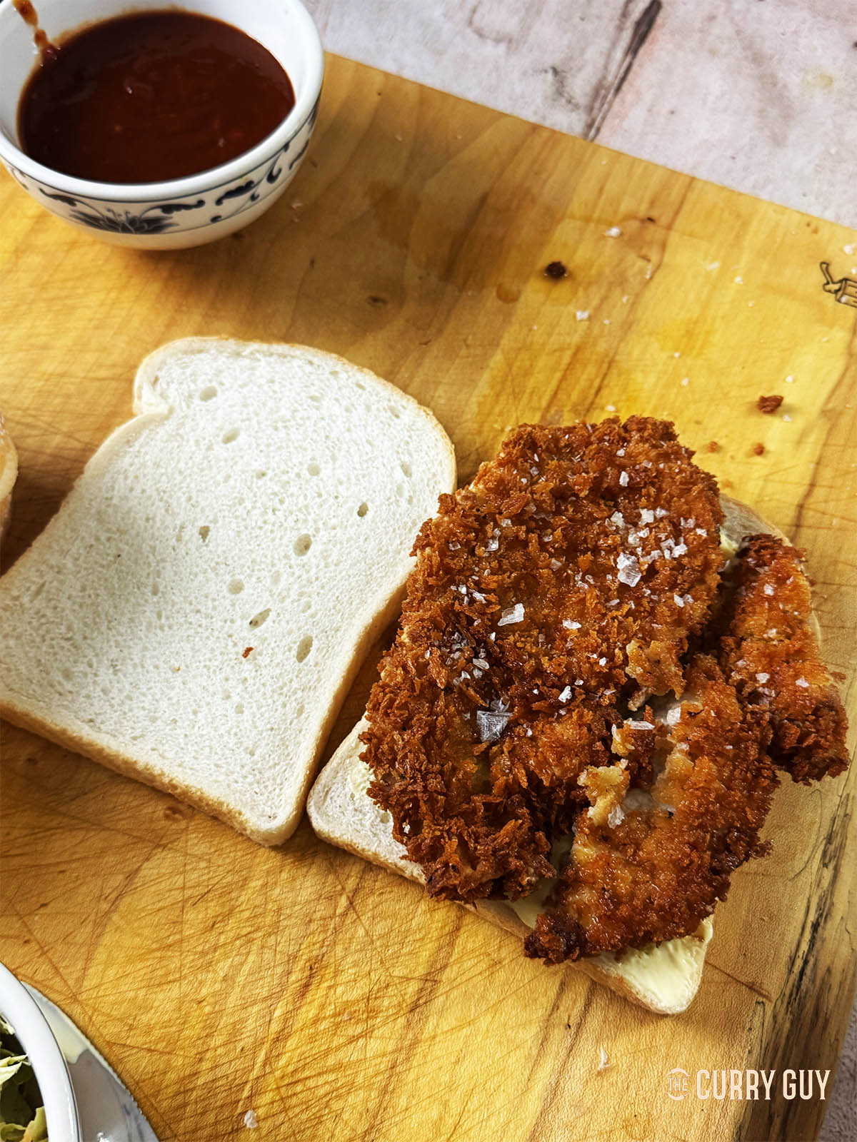 Placing tonkatsu on a slice of the sando bread.