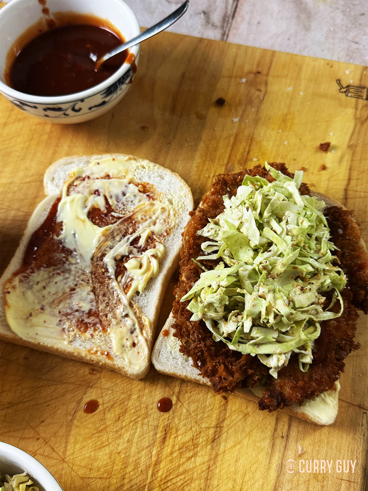 Adding coleslaw and more mayonnaise to the sando.