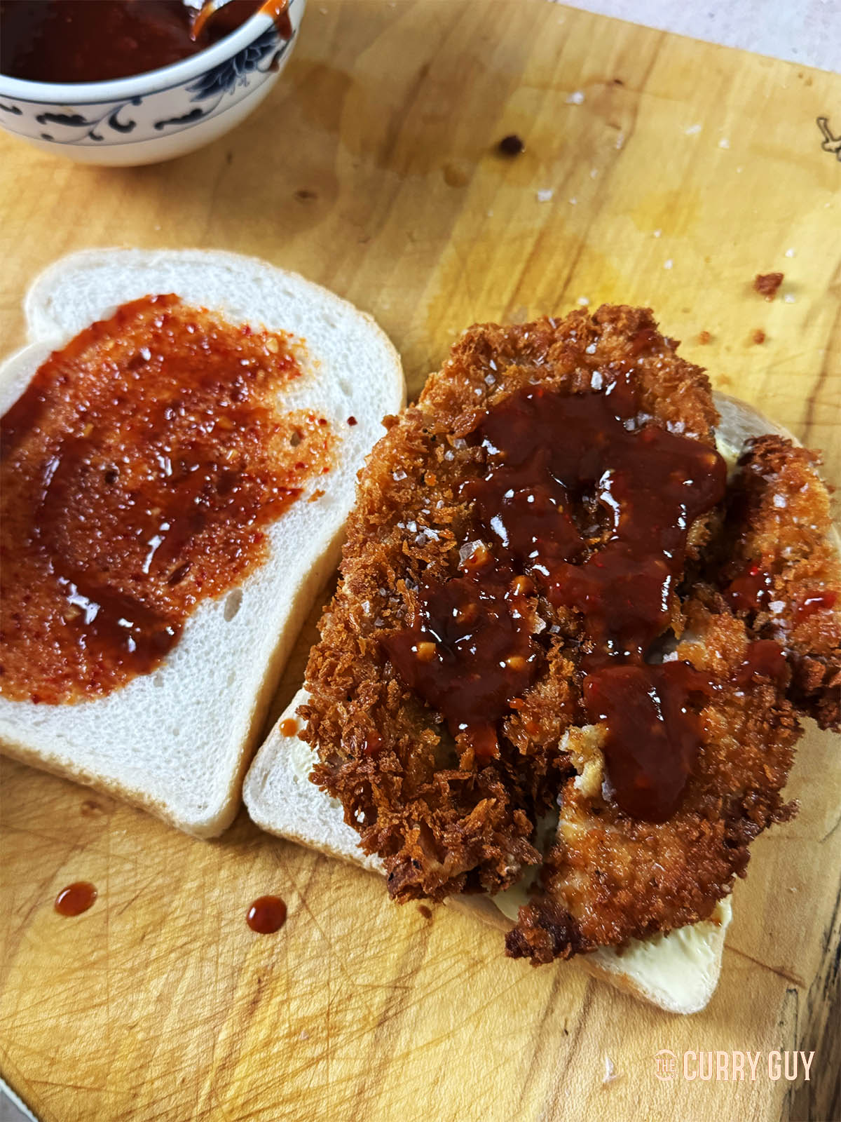 Adding tonkatsu sauce to the meat and bread.