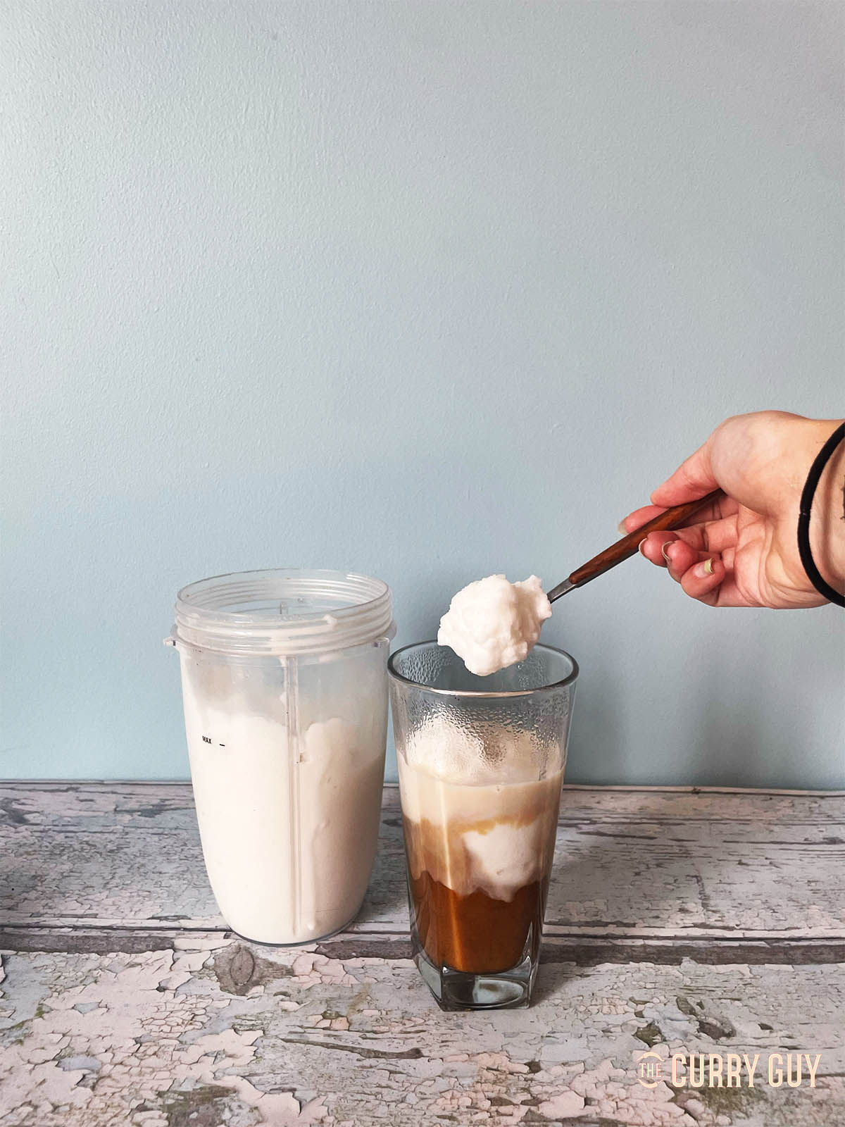 Adding the iced coconut mixture to the coffee.
