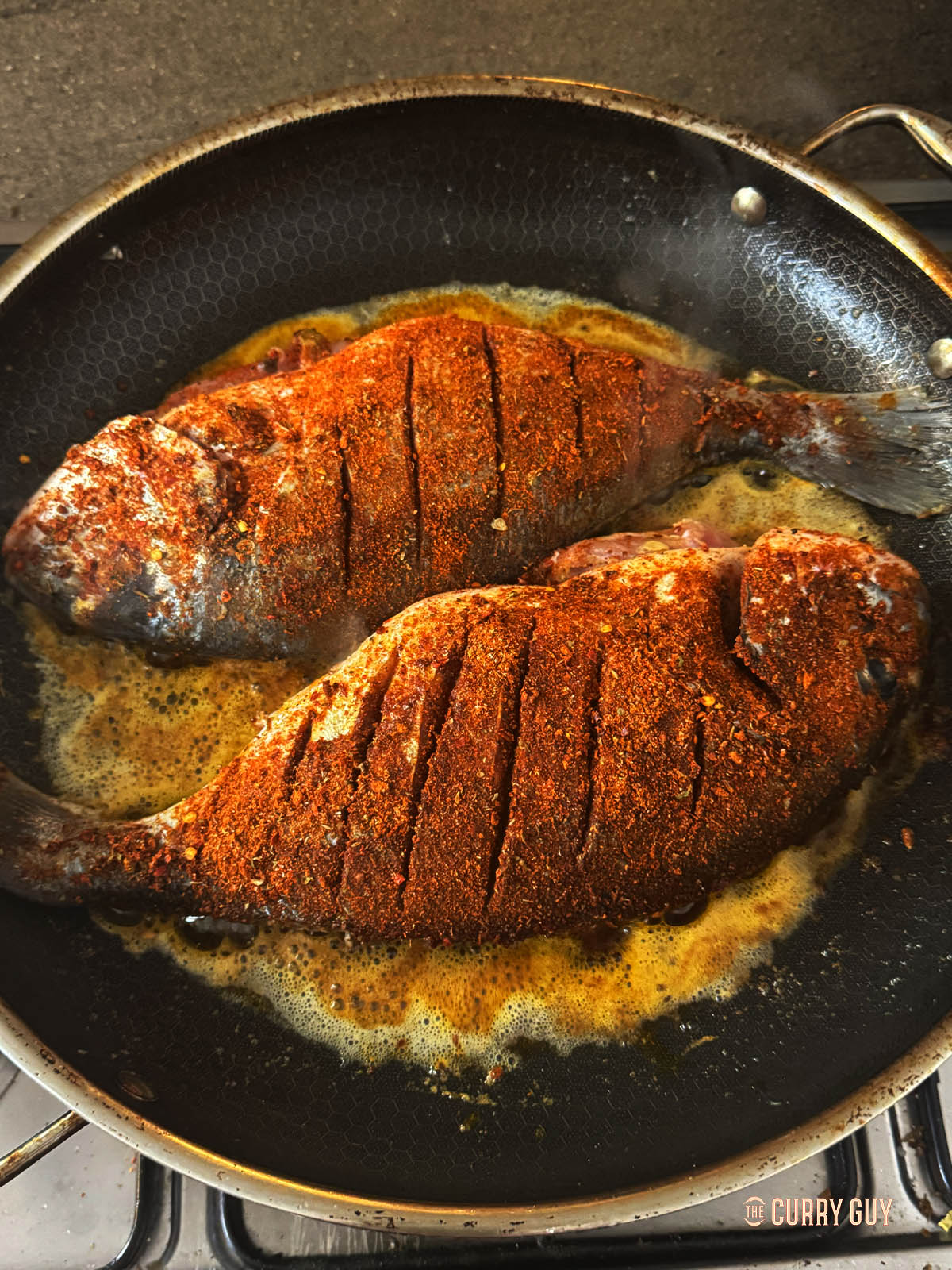 Adding the fish to the hot butter in the sizzling hot pan.