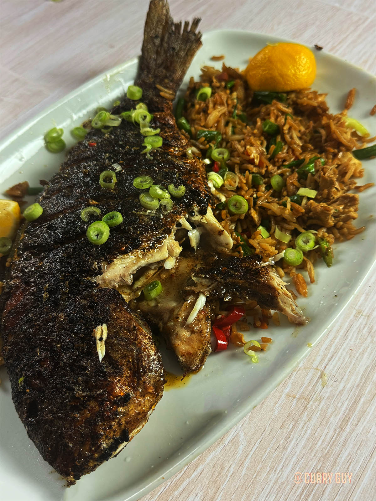 The Cajun fish on a serving plate with fried rice.
