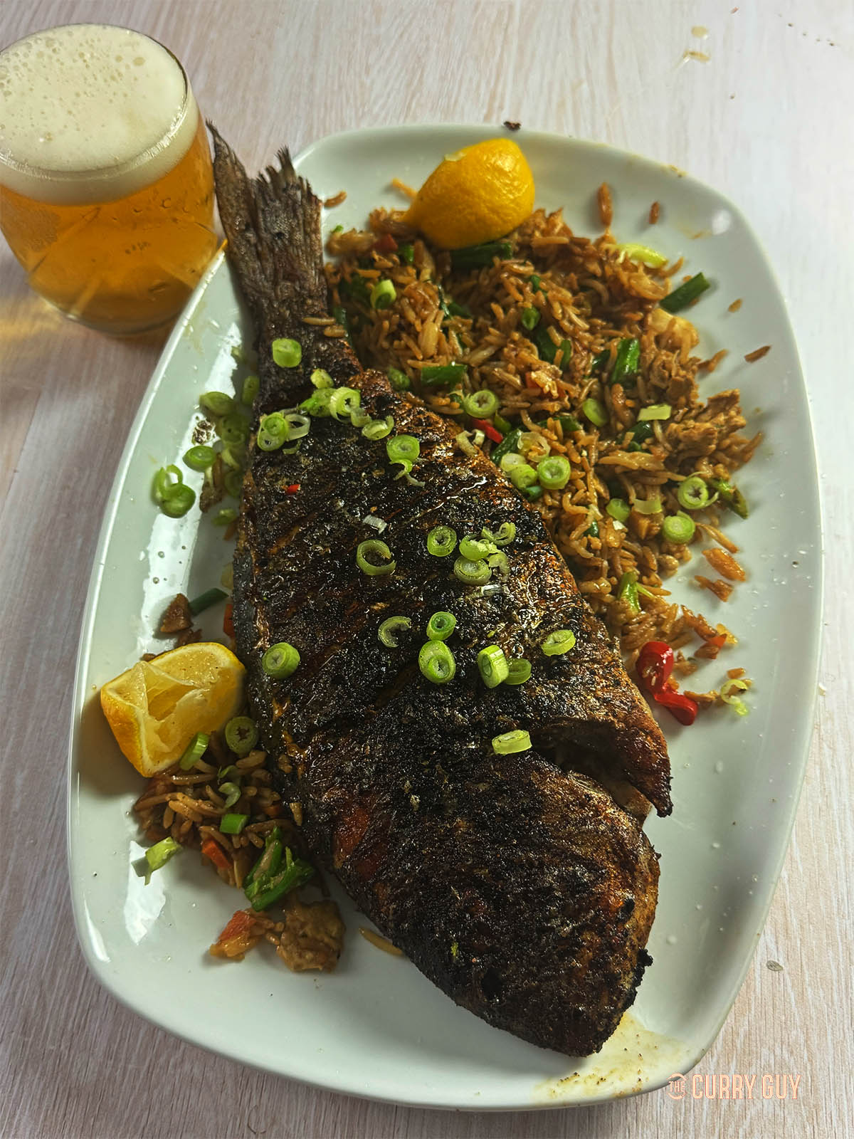Cajun Fish on a serving plate with fried rice.