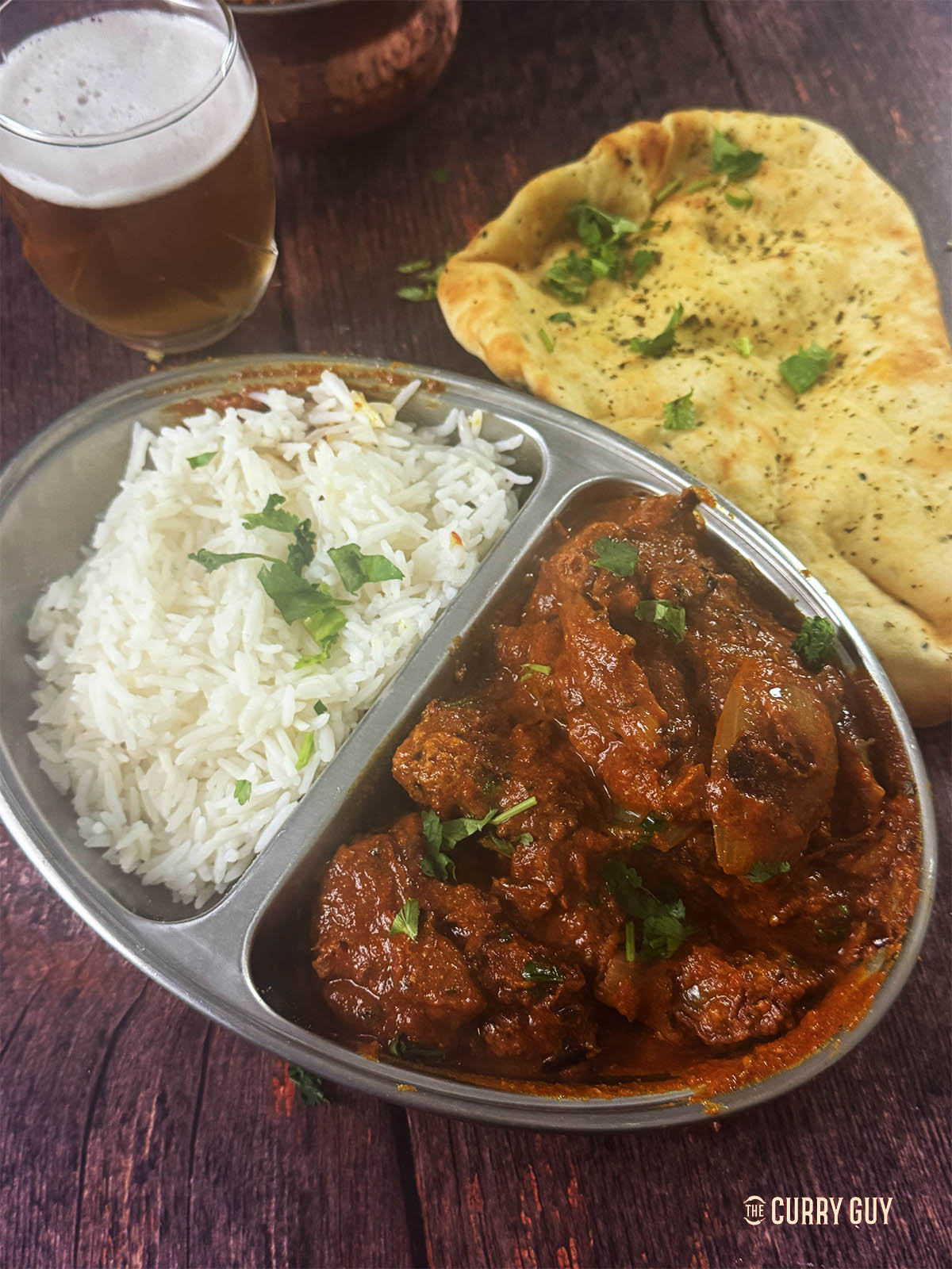 Chicken do pyaza at the table with rice and naan.
