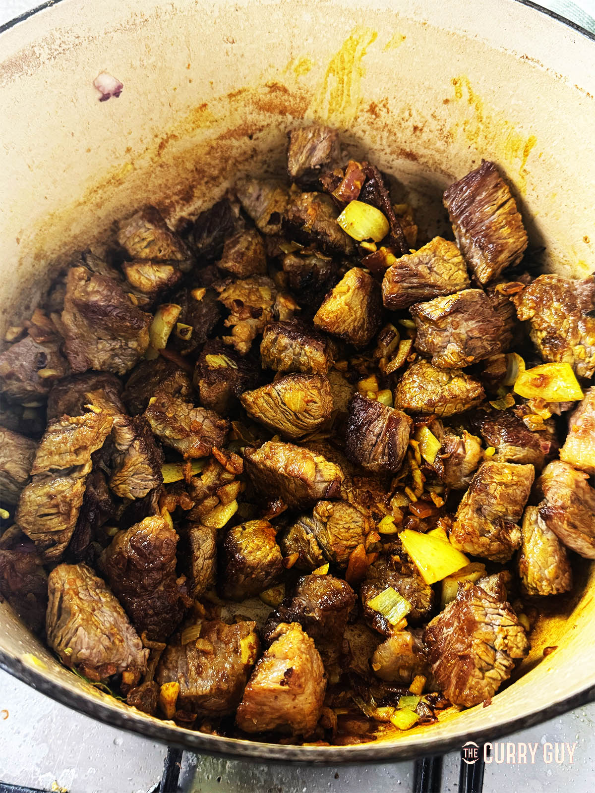 Returning the meat to the pan.