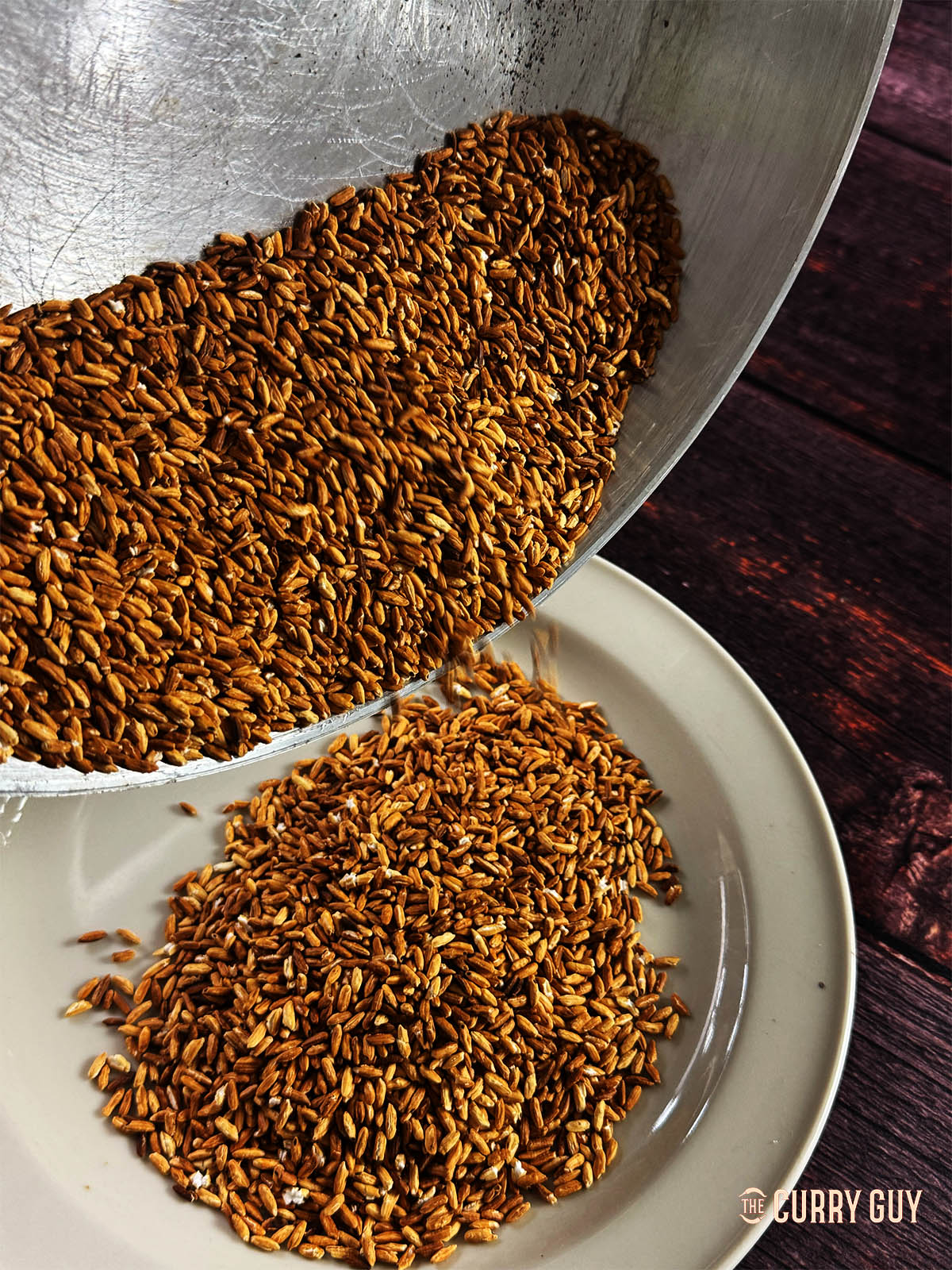 Transferring the toasted stick rice to a plate to cool.
