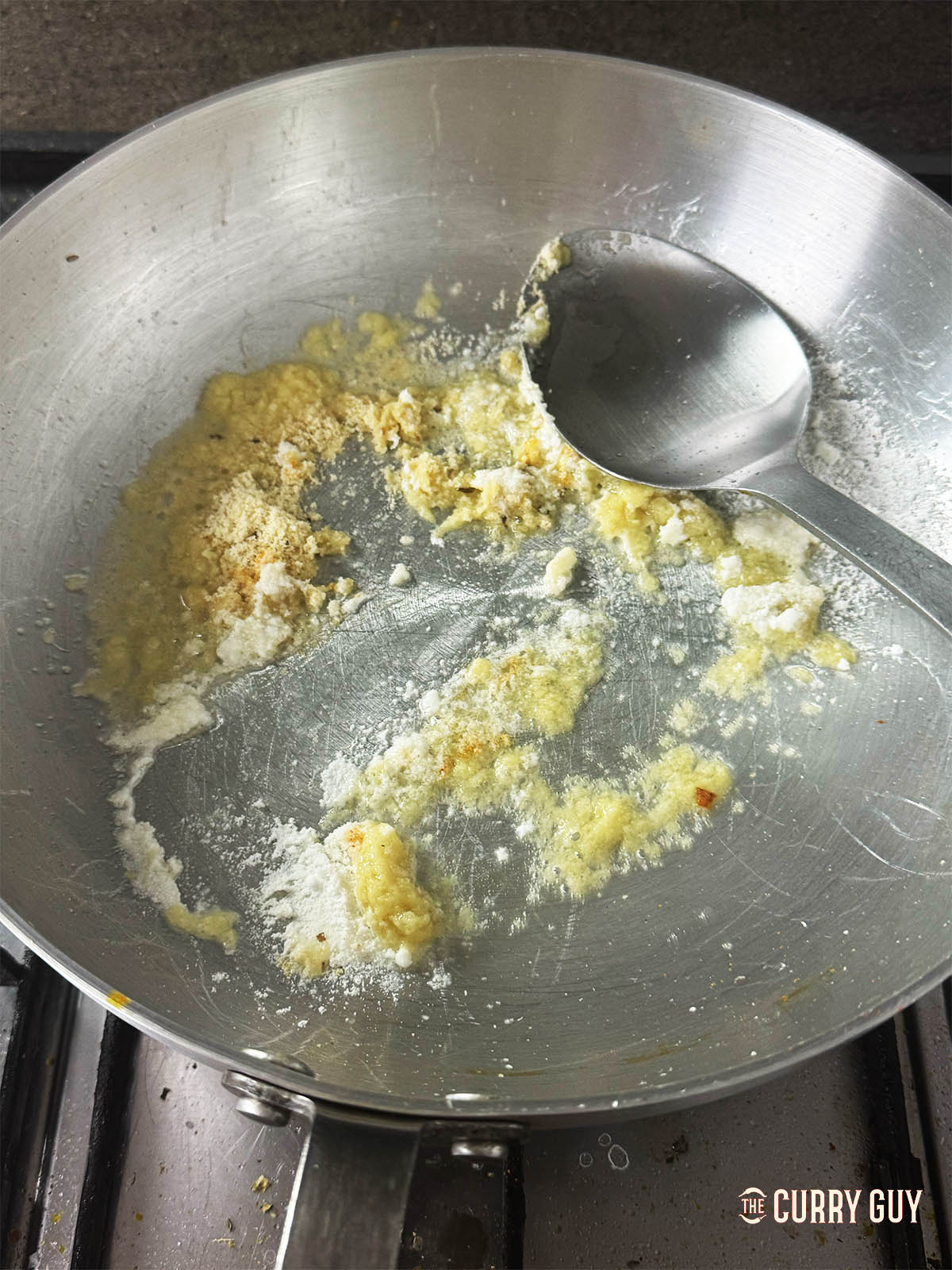 Adding the ground almonds and coconut powder to the pan. 