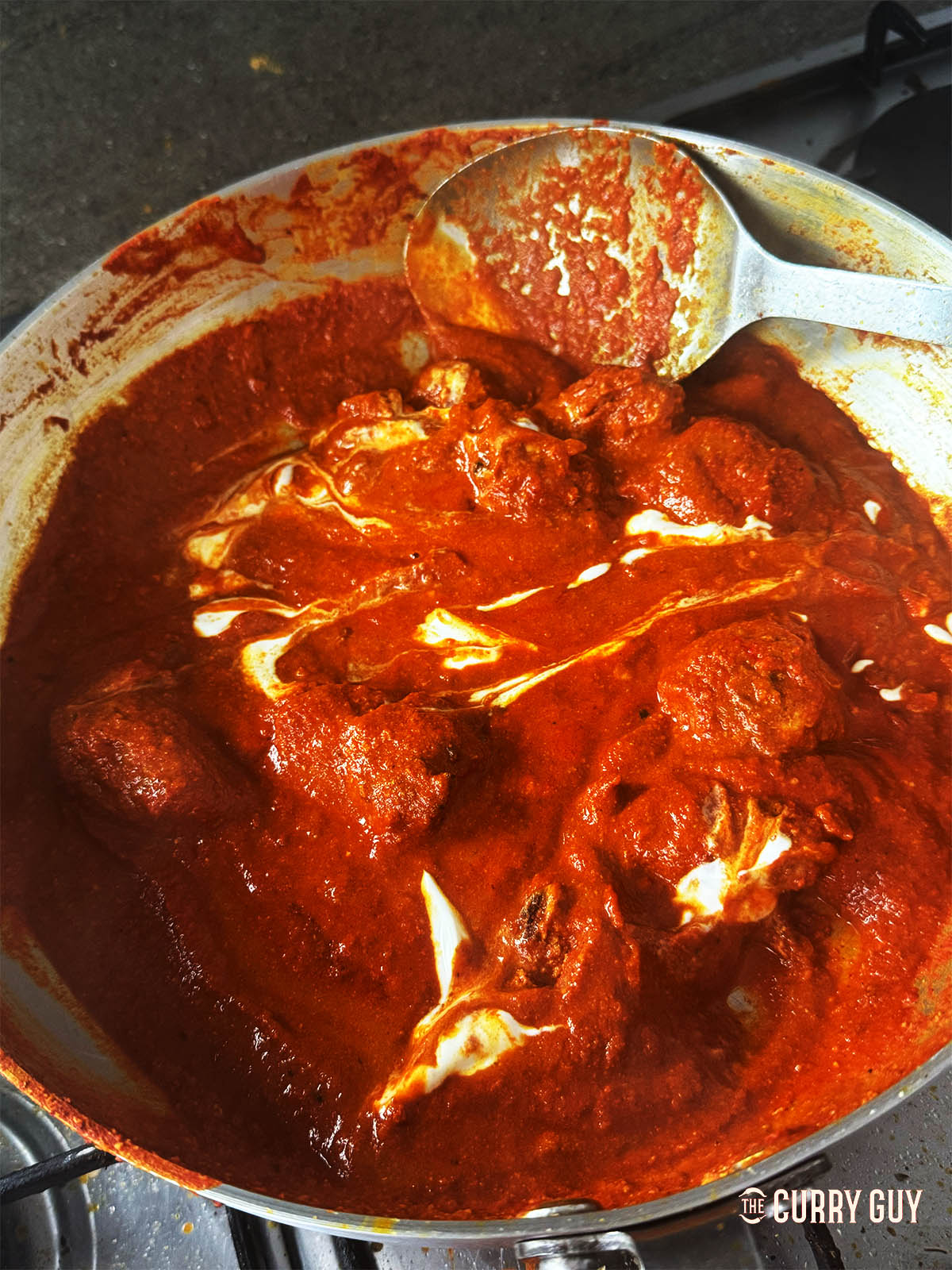 Stirring in more yoghurt to the pan and seasoning with salt to taste.