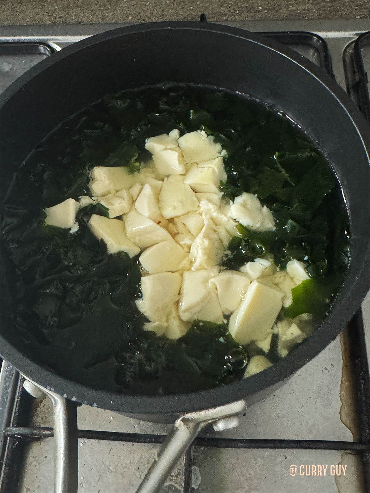 Adding the seaweed and silken tofu to the broth. 