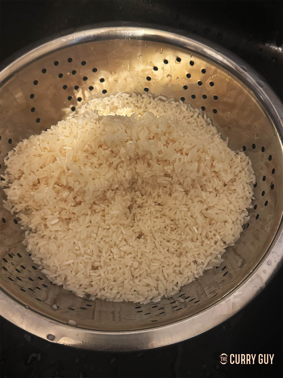 Rinsing the soaked rice through a colander.