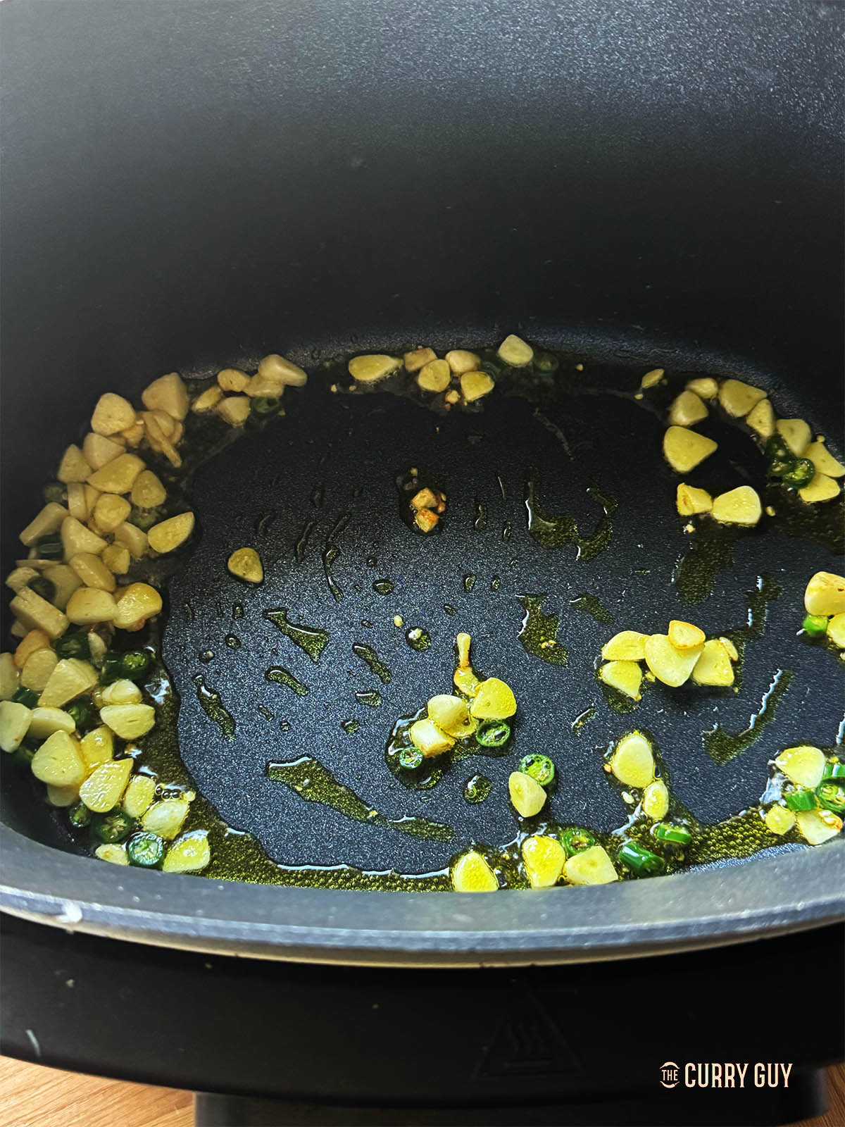 Frying the garlic and chillies in the slow cooker using sauté mode. 