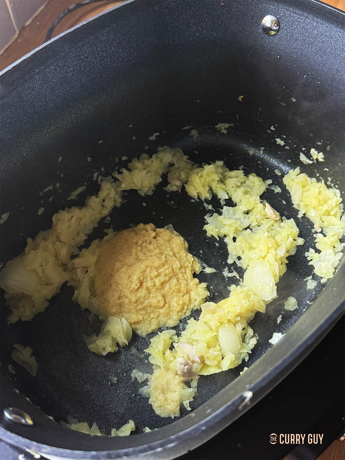 Adding garlic and ginger paste to the remaining onions. 